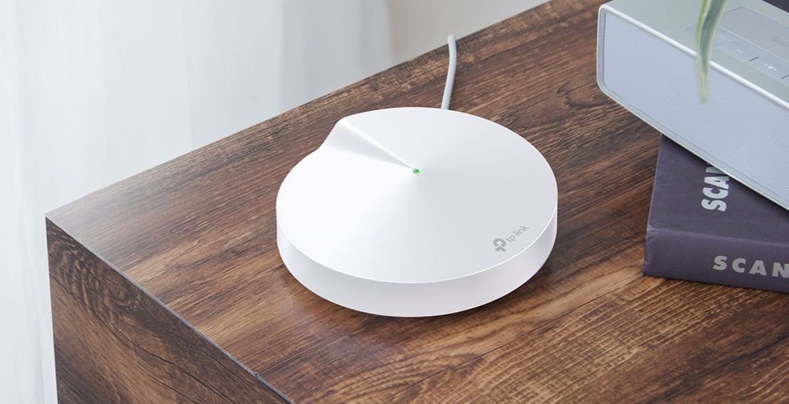 o roteador mesh Deco M5 da TP-Link em cima de uma mesa de madeira