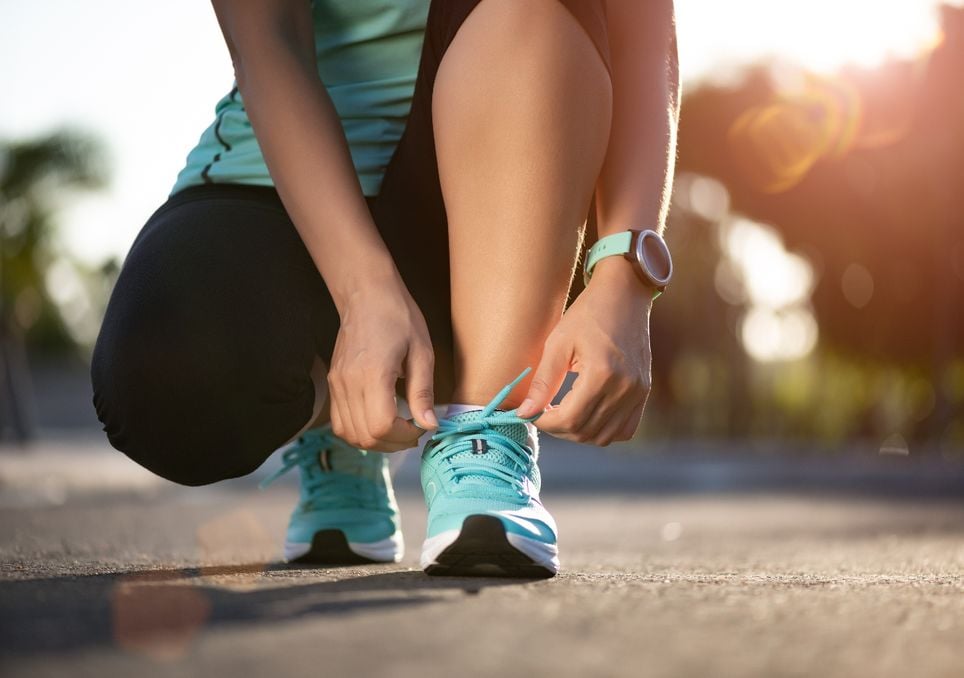 mulher amarrando os tênis