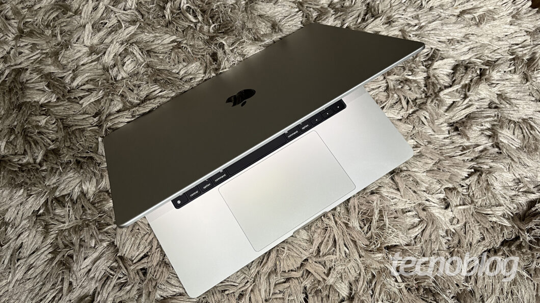 Imagem mostra um MacBook Pro M1 Max cinza sobre um tapete