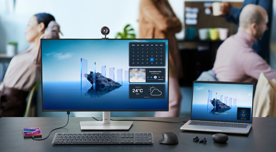 Mesa com monitor, notebook, celular e fones da Dell