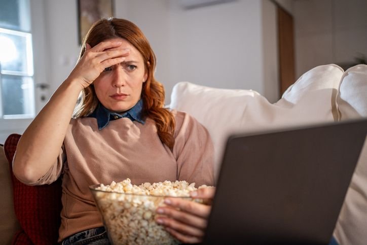 mulher-assistindo-streaming-enquanto-come-pipoca