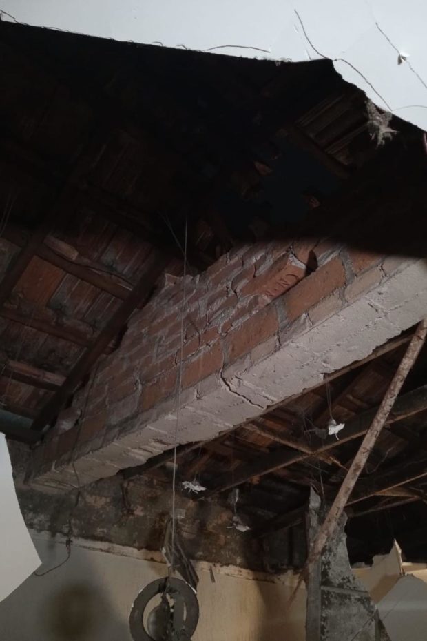 Teto danificado de uma das casas afetadas pelo incendio 