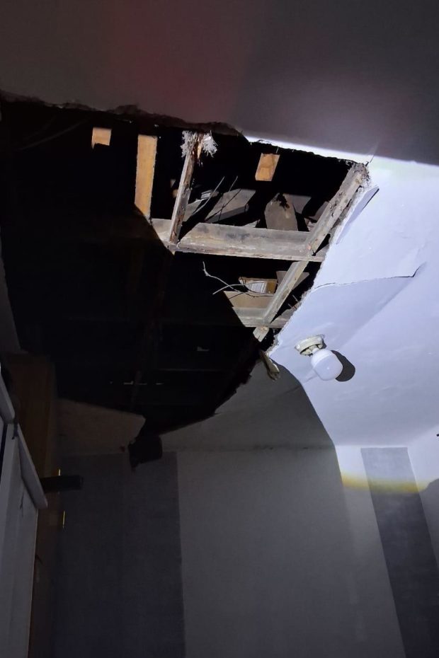 Buraco no teto danificado de uma das casas afetadas pelo incendio 