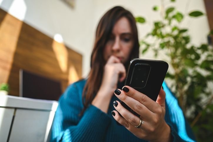 mulher-olhando-desconfiada-para-o-celular