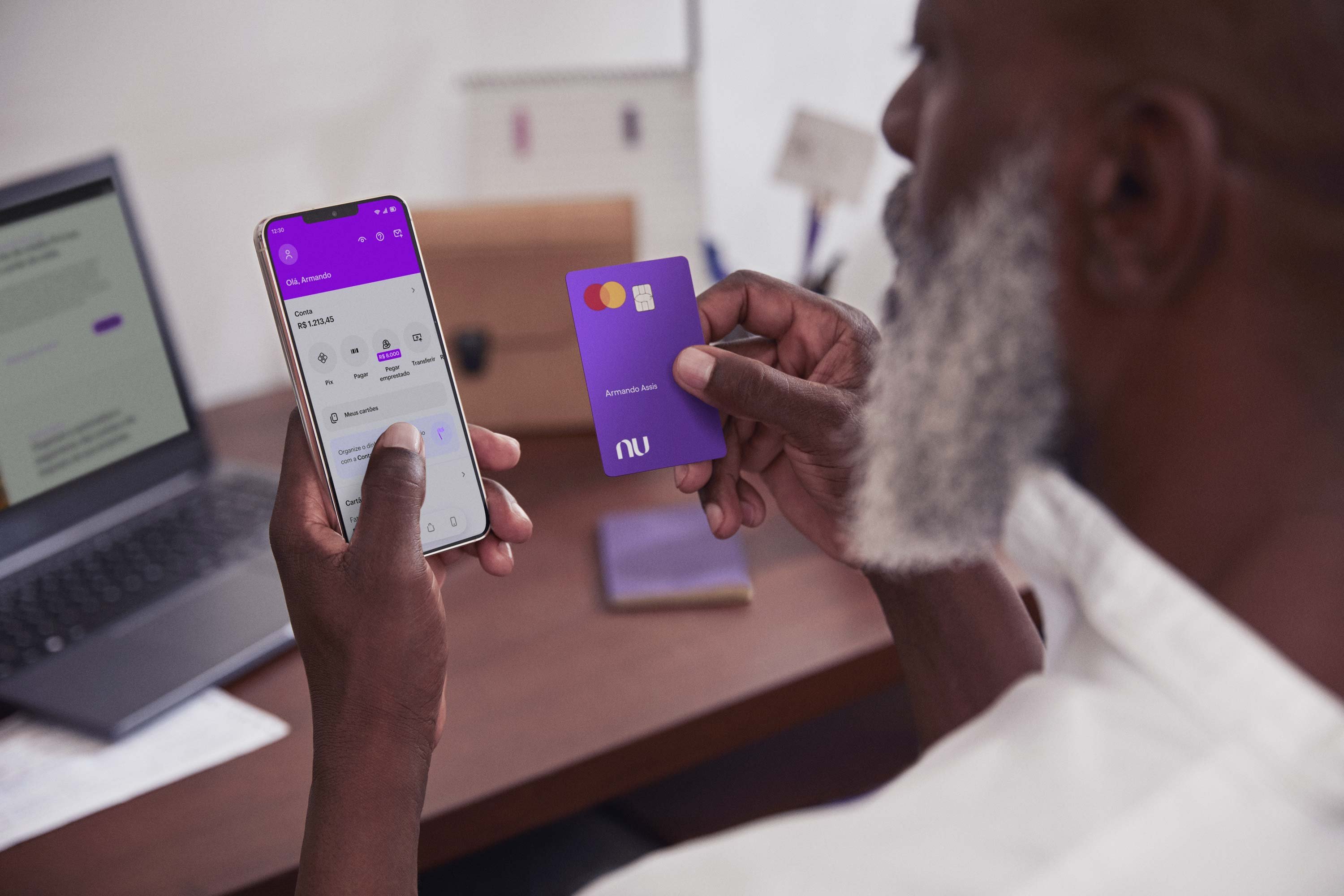 homem-olhando-para-o-app-nubank-e-segurando-cartao-de-credito